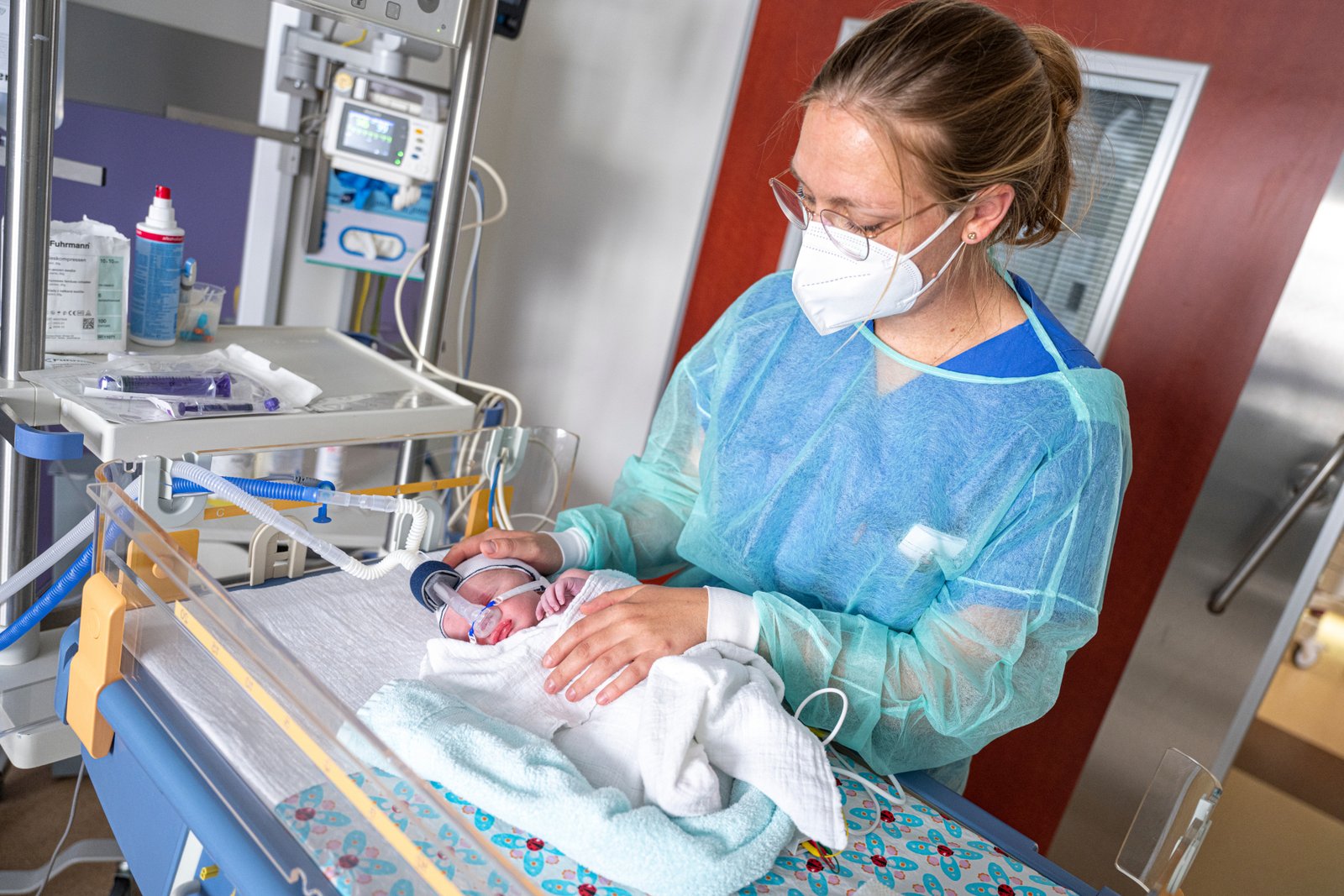 Das Bild zeigt ein Baby auf der Kinder-Intensivstation